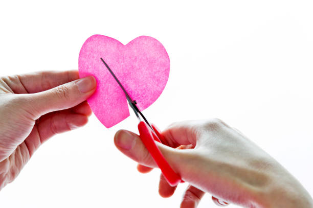 Human Hand Holding Scissors Cutting Heart Shape