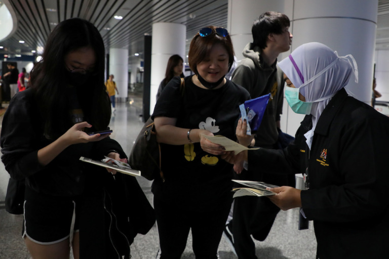 Malaysian Health Quarantine Officer Distributes Leaflet About Wuhan Pneumonia To Passengers At Kuala Lumpur International Airport In Sepang