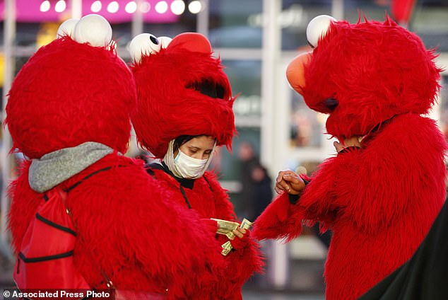 25930666 8105199 A_mask_wearing_costumed_character_are_pictured_in_New_York_Times A 36_1584104694163