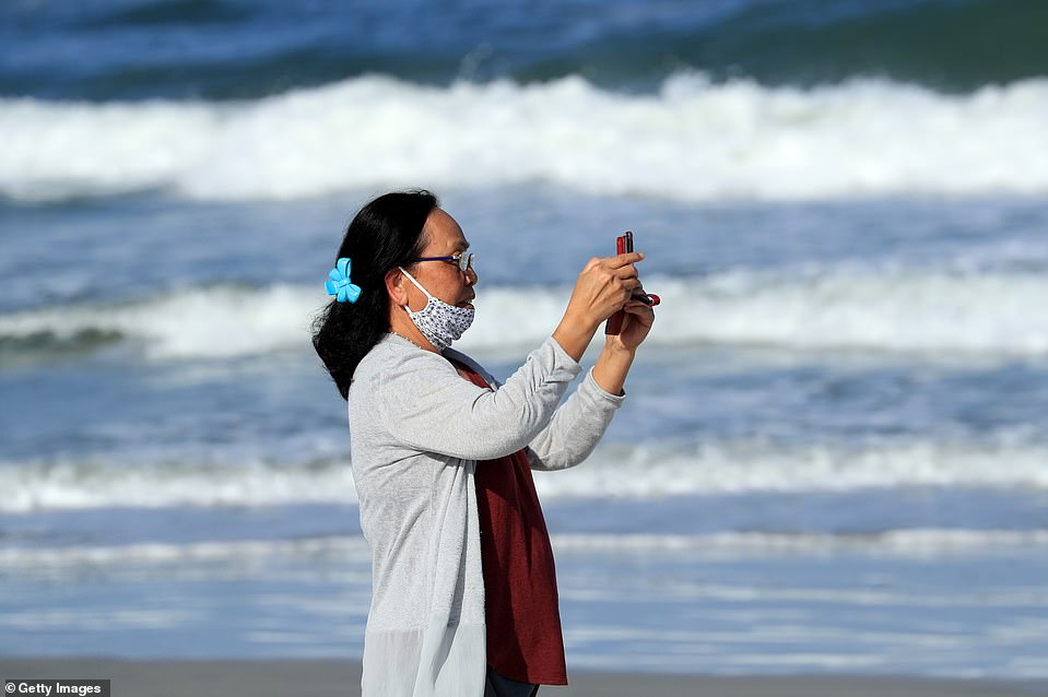 27339746 8229933 A_woman_takes_a_photo_with_her_phone_as_Jacksonville_residents_w A 17_1587195036186