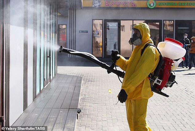 27455008 8240207 A_government_worker_sprays_disinfectant_at_Savyolovsky_Railway_S A 33_1587463230373