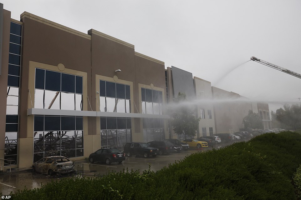 29279550 8393533 Fire_trucks_pour_streams_of_water_on_a_warehouse_fire_in_Redland A 38_1591399361810