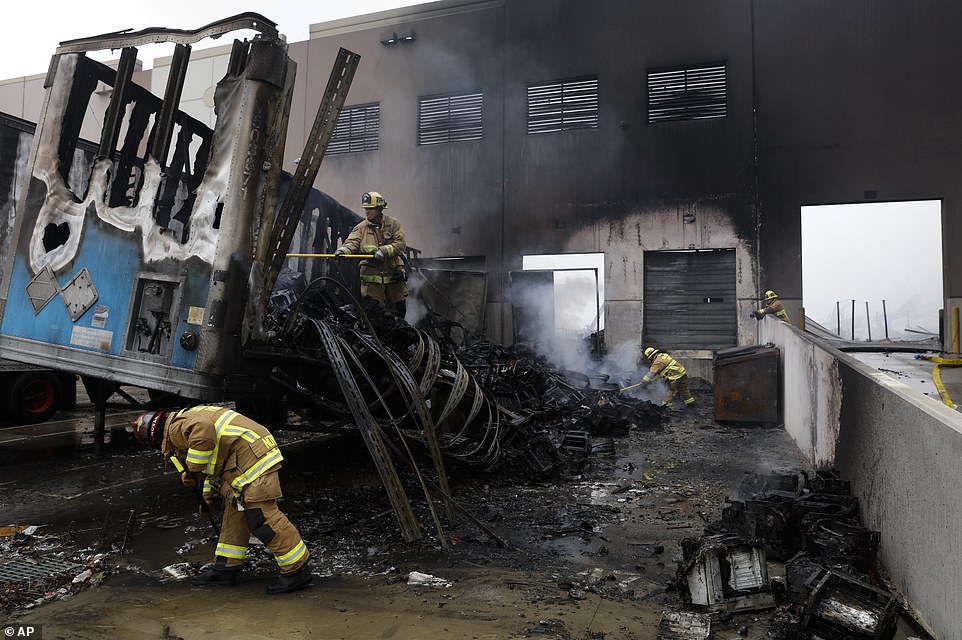 29279556 8393533 Firefighters_put_out_hot_spots_at_a_warehouse_destroyed_in_Redla A 42_1591399361905