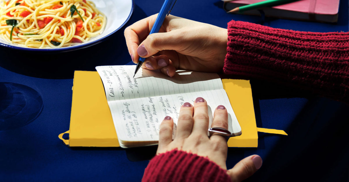 Woman Taking Notes In Planner At Lunch.