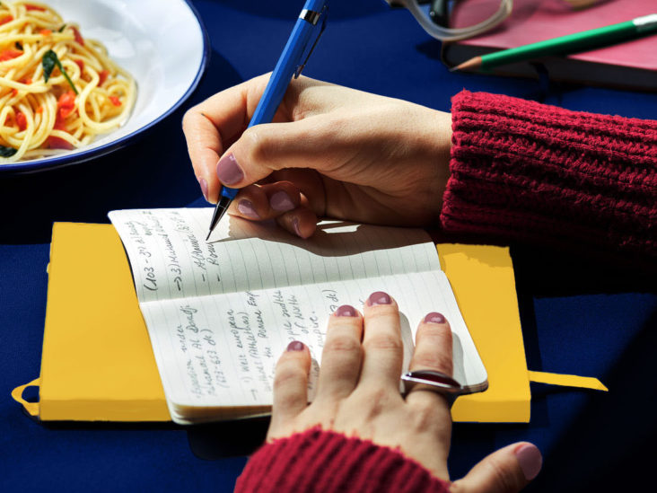 Woman Taking Notes In Planner At Lunch.