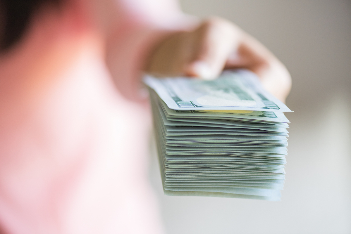 Soft Focus On Woman Hands Proposing Money Us Dollar Bills To You.