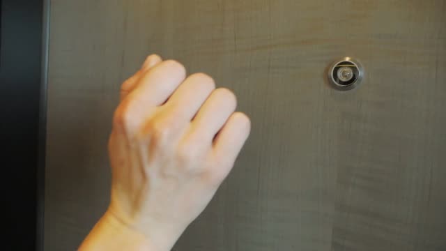 A Man Is Knocking At The Door. The Hand Is Shown Close Up.
