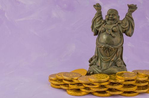 Buddha,Sculpture,With,Gold,Coin,Donations,On,Pink,Background