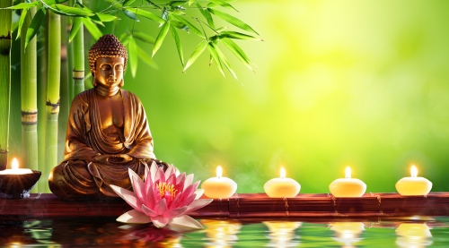 Buddha,Statue,With,Candles,In,Natural,Background