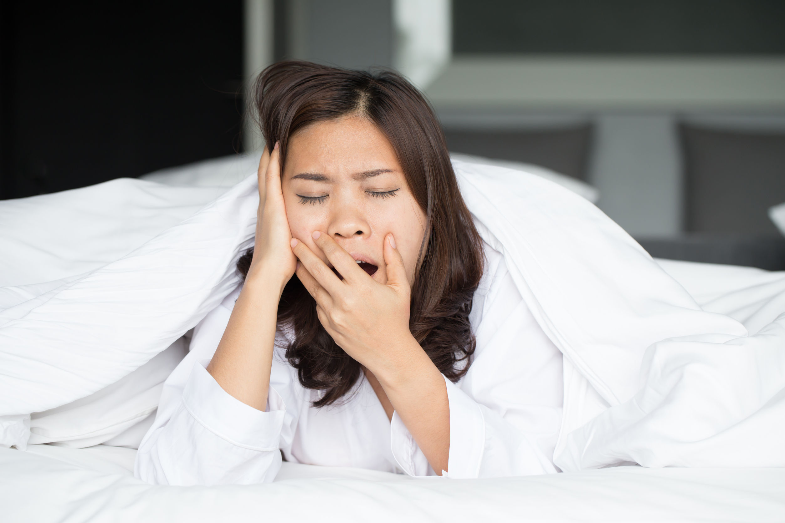 39062171   Sleepy Asian Woman Yawning In Bed At Home