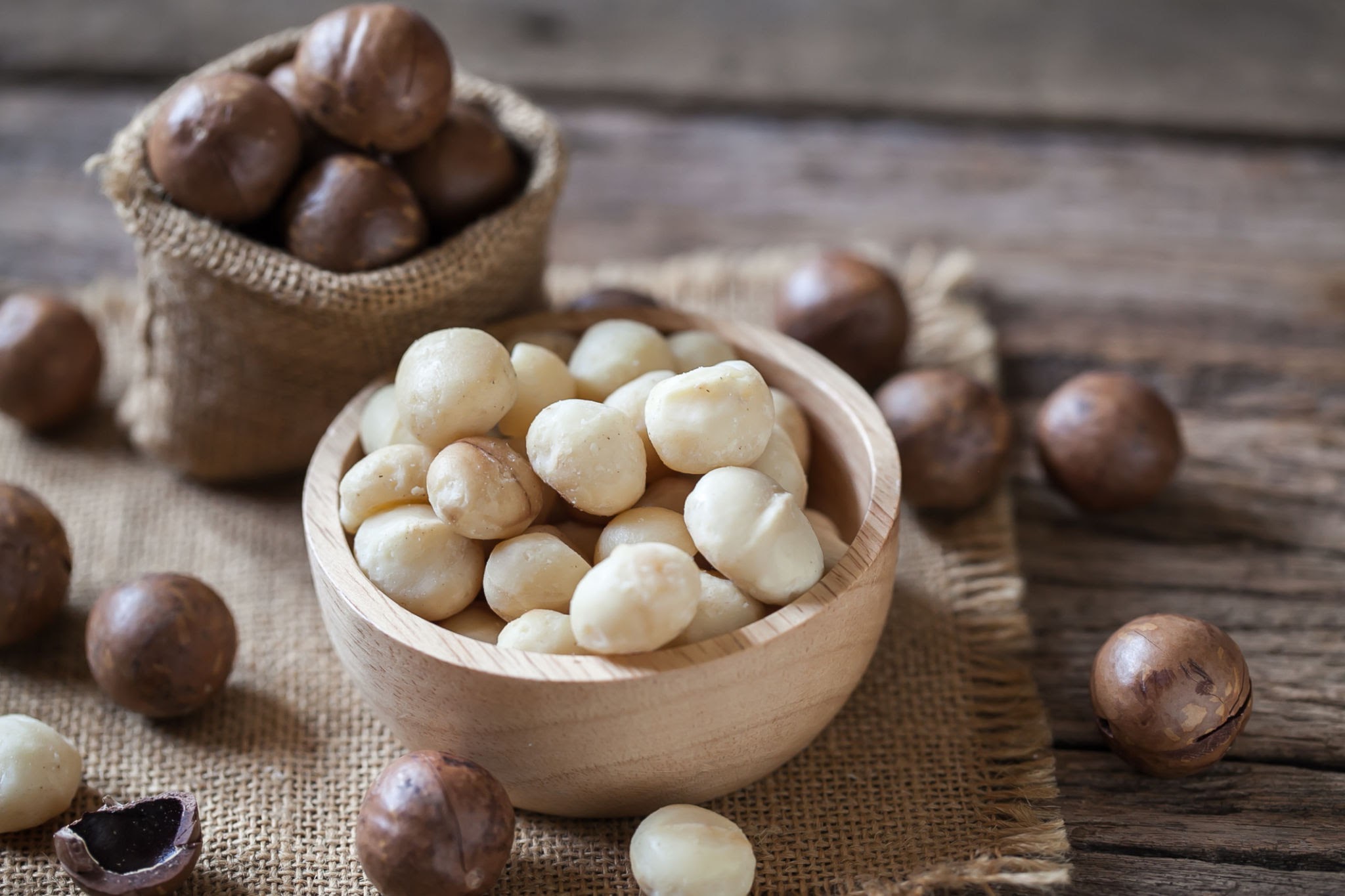 Macadamia Nuts On Sackcloth And Wooden Background