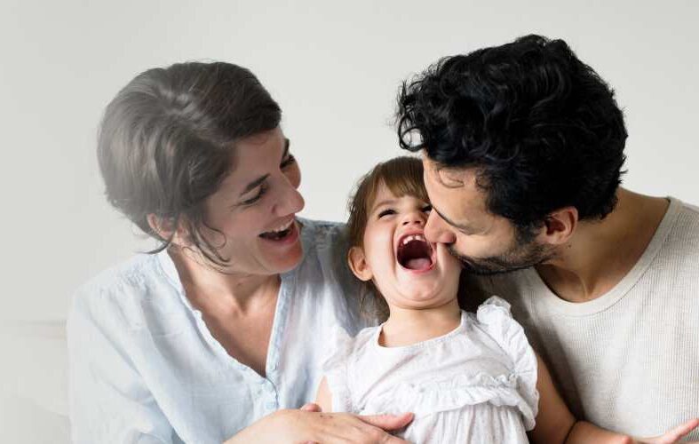 Happy Parents Laughing Together With Daughter Compressed E1631883835471