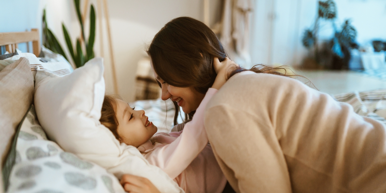 Mother Putting Daughter To Bed