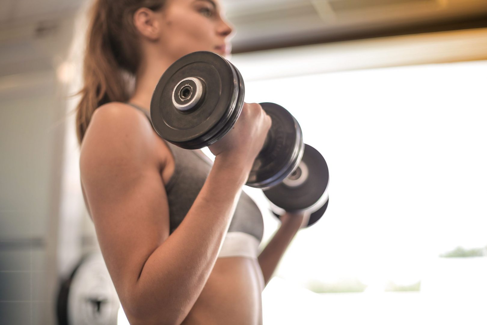 Canva Woman In Gray Sports Bra Holding Black Dumbbell Scaled 1