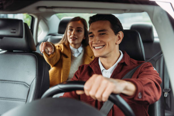 Smiling Taxi Driver With Woman Passenger Pointing On Road