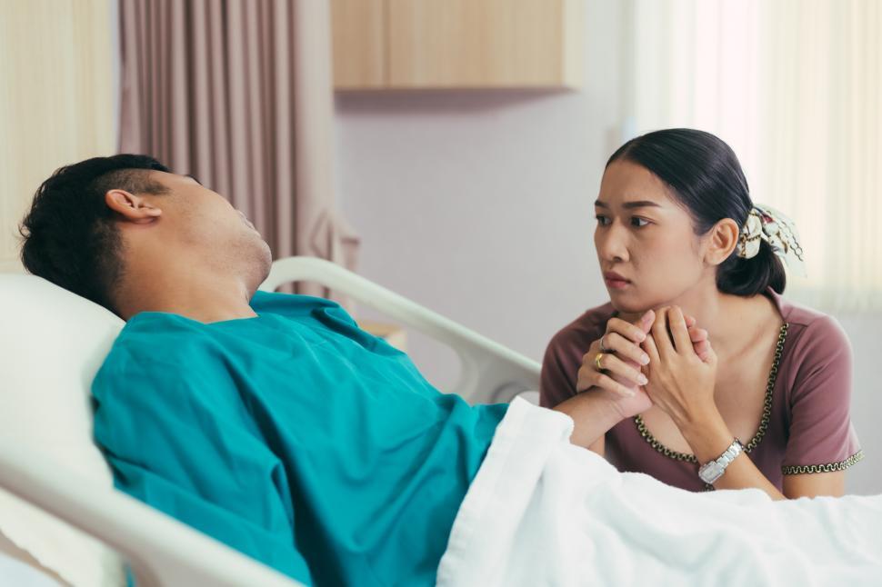 Wife Holding Hand And Look Worried At Husband On Bed